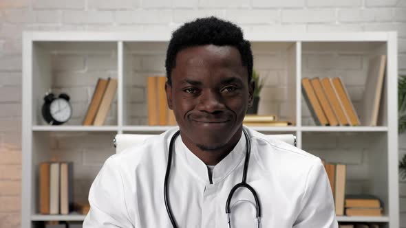 Smiling African American Man Doctor in Medical Coat Looking Camera in Hospital