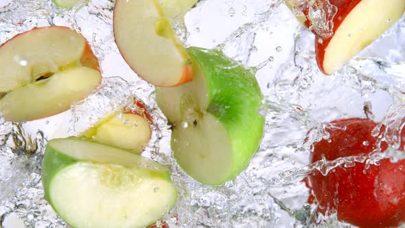 Super Slow Motion Shot of Red and Green Apple Cuts Falling and Splashing Into Water at 1000Fps