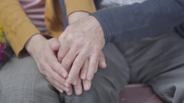 Old Woman's Hands Holding the Hand of Old Man