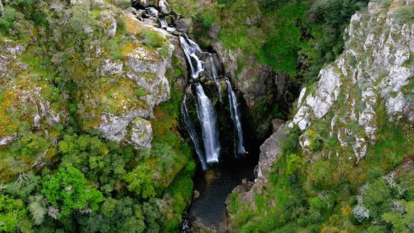 Aerial High Angle View Of Fervenza do Toxa Waterfalls Cascading Down Rockface. Establishing Shot