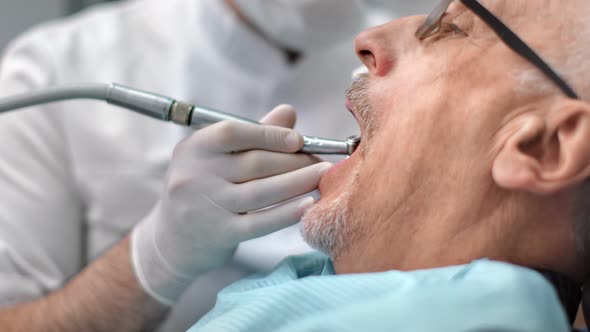 Senior Man Patient of Dentistry with Open Mouth During Treating