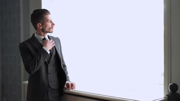 Men's Fashion and Style. Portrait of Handsome Young Groom By the Window Indoors