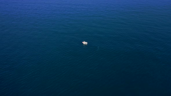 061_ojra.uas_ocean_BOAT_AerialView_4k. boat in the middle of the ocean bird's eye view on a sunny da