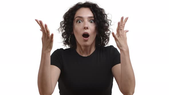 Closeup of Beautiful Young Woman with Short Curly Hair Black Tshirt Looks Closer at Camera and Gasp