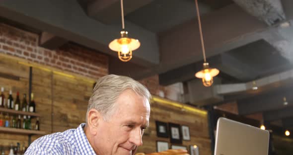 Senior man using laptop in the restaurant 