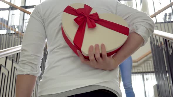 Boyfriend Hiding a Surprise Gift and Walking Towards His Girlfriend on Her Special Day