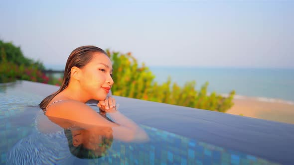 Young asian woman enjoy around outdoor swimming pool for leisure