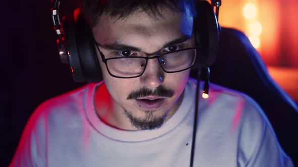 Closeup Man's Face Playing at Computer with Headphones and Screaming Anger Front View