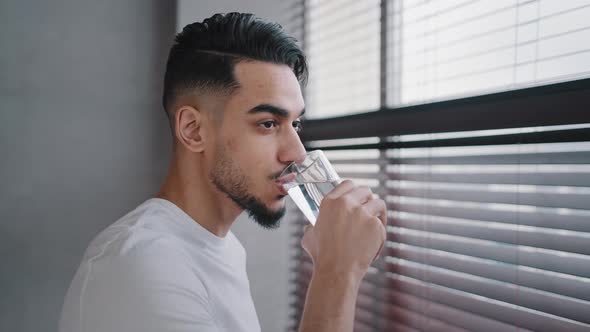 Hispanic Indian Arab Bearded Guy Millennial Man Looking Window at Home in Gym Drinks Clean Delicious