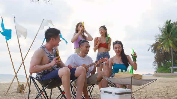 Group of Asian young man and woman having party on the beach together.