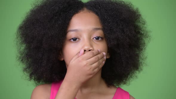 Young Cute African Girl with Afro Hair Covering Mouth As Three Wise Monkeys Concept