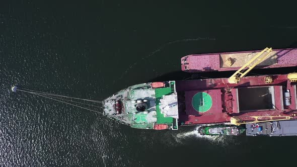 Top View of Cargo Bulker Lie on Anchor in with Barges on Both Sides of Vessel