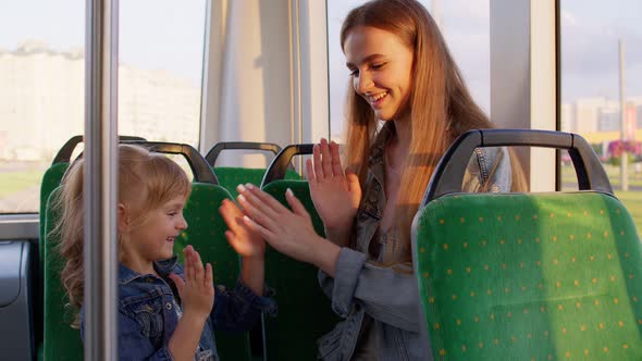 Family Rides in Public Transport Tram Mother with Girl Sit Together and Playing Game Clapping Hands