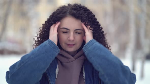 Happy Young Woman with Afro Curls in a Winter City