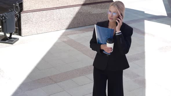 Woman Lawyer Talking Phone While Walking in the Business District of the City.