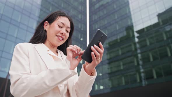 Young Asian Elegant Professional Business Woman Using Cell Phone to Text Outside the Office Female