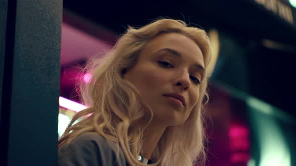Blonde Model Face Looking Camera in Neon Lights in Night City