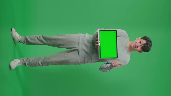 Full Body Of Man Showing Thumbs Up Gesture While Holding Green Screen Computer On Green Screen