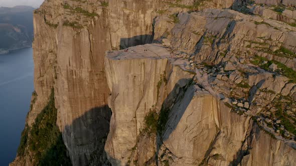 Wide Drone Shot Of Hikers On Rocky Mountain In Sunlight