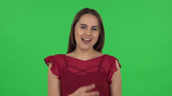 Portrait of Tender Girl in Red Dress Is Making a Rock Gesture and Enjoying Life. Green Screen