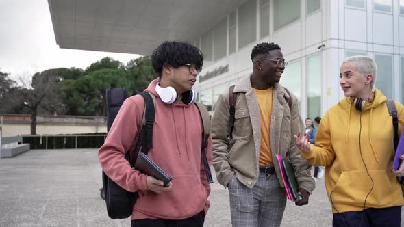 Three Mixedrace Young Student Friends Walking Around University Campus Sharing Stories Laughing