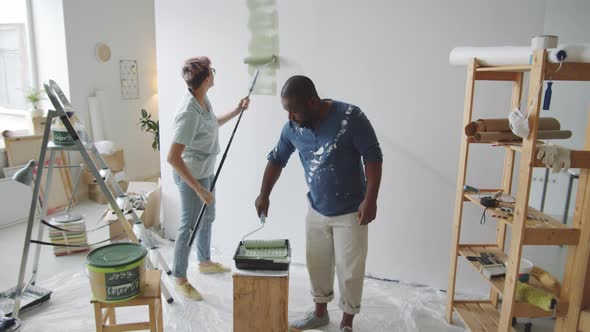 Multiethnic Couple Painting Walls Together