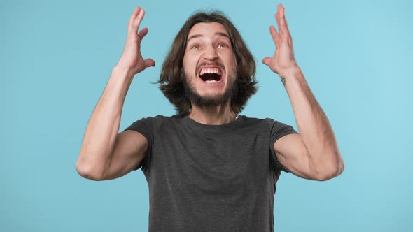 Portrait of Furious Man Wearing Casual Gray Tshirt Angrily Screaming and Gesturing Intensely with