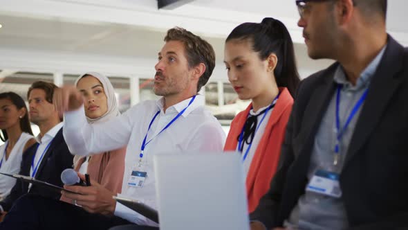 Male audience member at a business conference asking a question