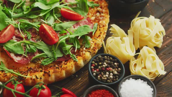 Italian Food Background with Pizza, Raw Pasta and Vegetables on Wooden Table