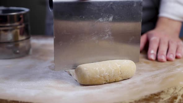 The Cook Uses a Cutter From a Large Piece of Dough Lying on a Parchment Sprinkled with Flour