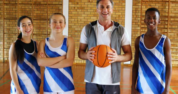 Portrait of coach and schoolkids standing with basketball 4k