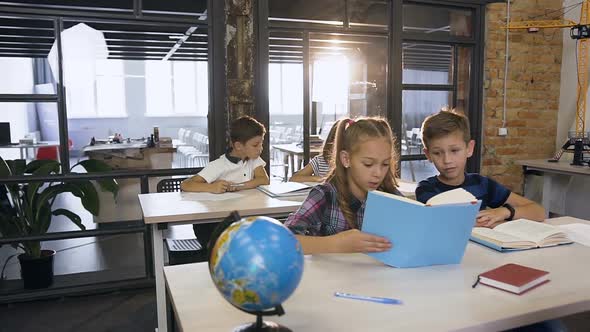 Caucasian Pupils of Elementary School Learning Independently in the Class while Male Korean Teacher