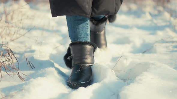 Woman Legs Walking In Snow. Female In Snowy Weather At Cold Temperature Walking Alone.