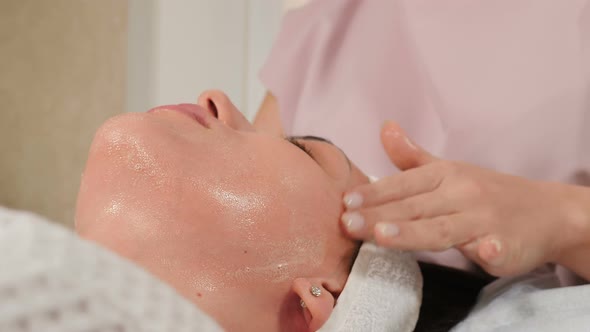 Wellness and Beauty Salon. Relaxed Woman Lying on Couch and Having Deep Cleansing Nourishing Facial