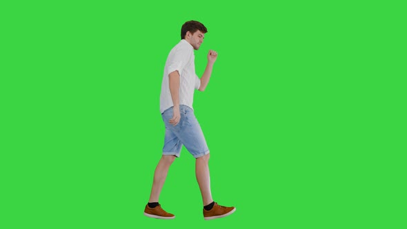 Young Man in Casual Clothes Dancing Happily While Walking on a Green Screen, Chroma Key.