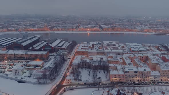 Aerial Drone View of Snowcovered Roofs of Buildings in a Winter Evening Night Illumination of