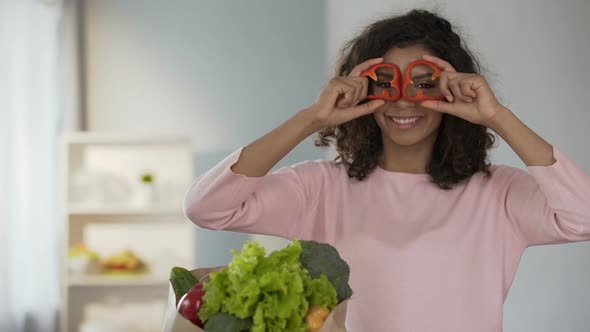 Beautiful Woman Bringing Pepper Rings to Eyes, Smiling, Healthy Eating Habits