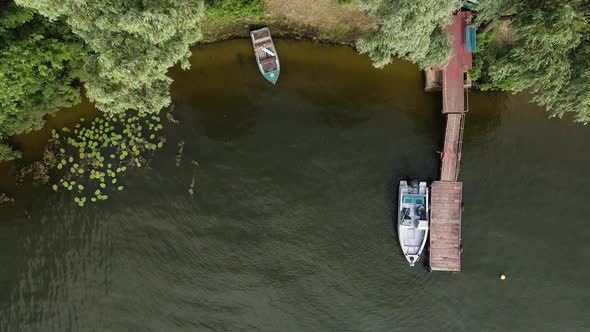 Aerial Drone View of a Moored Boat at a Wooden Pier on the River