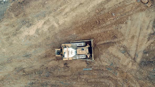 Working Tractor Moves Sand While Driving on a Quarry