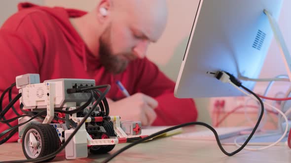 Close Up of an Young Man That is Learning Robotics Lessons Using Computer