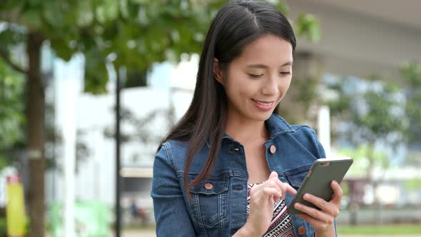 Woman looking at cellphone at outdoor park