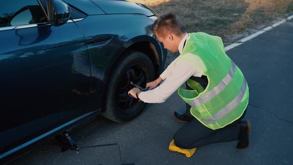 Man Changes Wheels on a Car