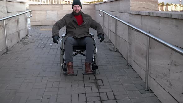 Cheerful Disabled Man Moving Down Wheelchair Ramp