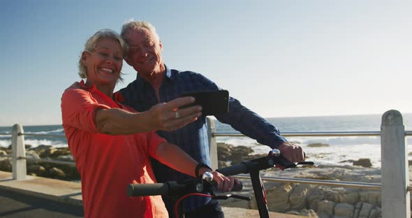 Senior couple taking picture alongside beach