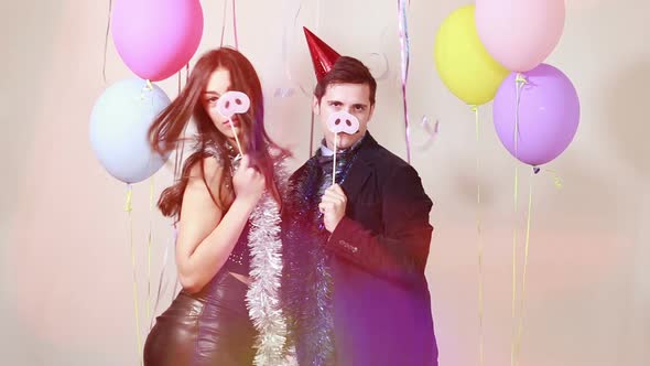 Slow motion of fun crazy couple playing with props in photo booth