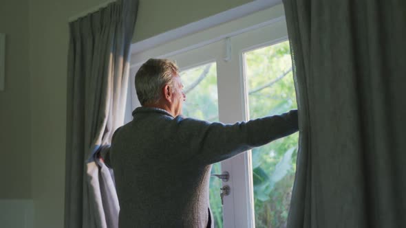 Animation of happy caucasian senior man revealing curtains