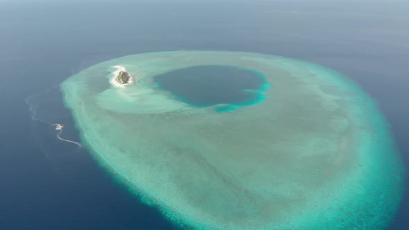 Aerial: Flying over idyllic atoll, scenic travel destination in Indonesia