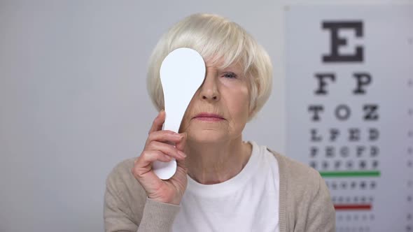 Aged Lady Closing Eye and Shaking Head Upset With Sight Test Result, Poor Vision