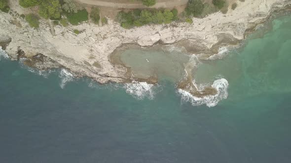 Lonely Girl On An Air Mattress In a Small Lagoon. Aerial Footage. Flat Color