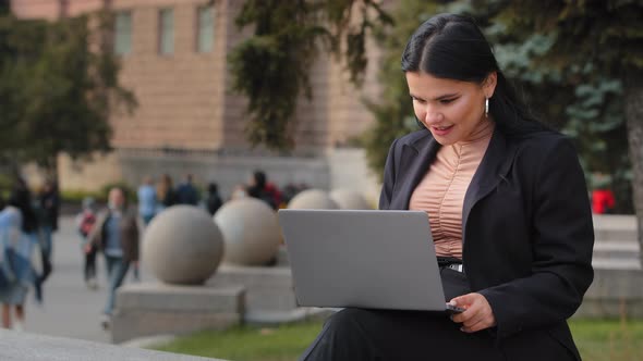 Young Businesswoman Freelancer Student Sitting Outdoors Reading Email on Laptop Smiling Laughing